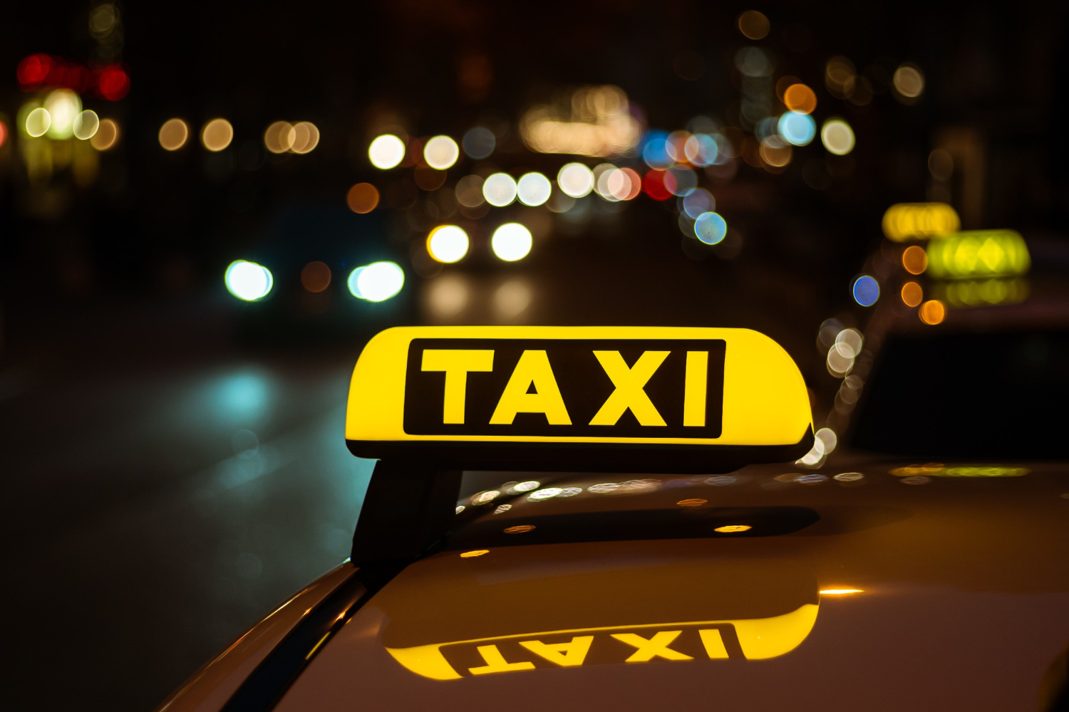 yellow-black-sign-taxi-placed-top-car-night